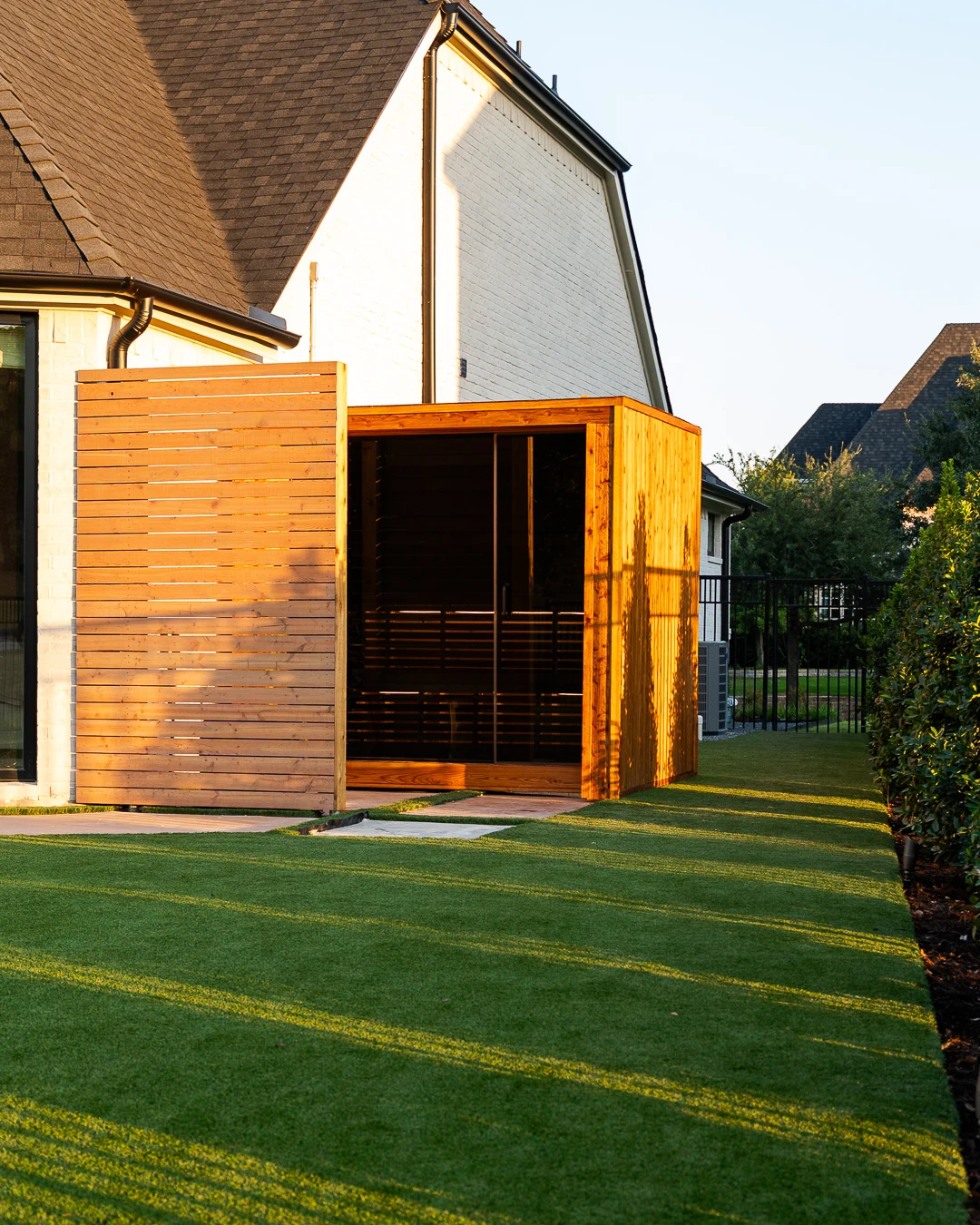 Cedar sauna interior with benches, slatted backrest, and wall sconce