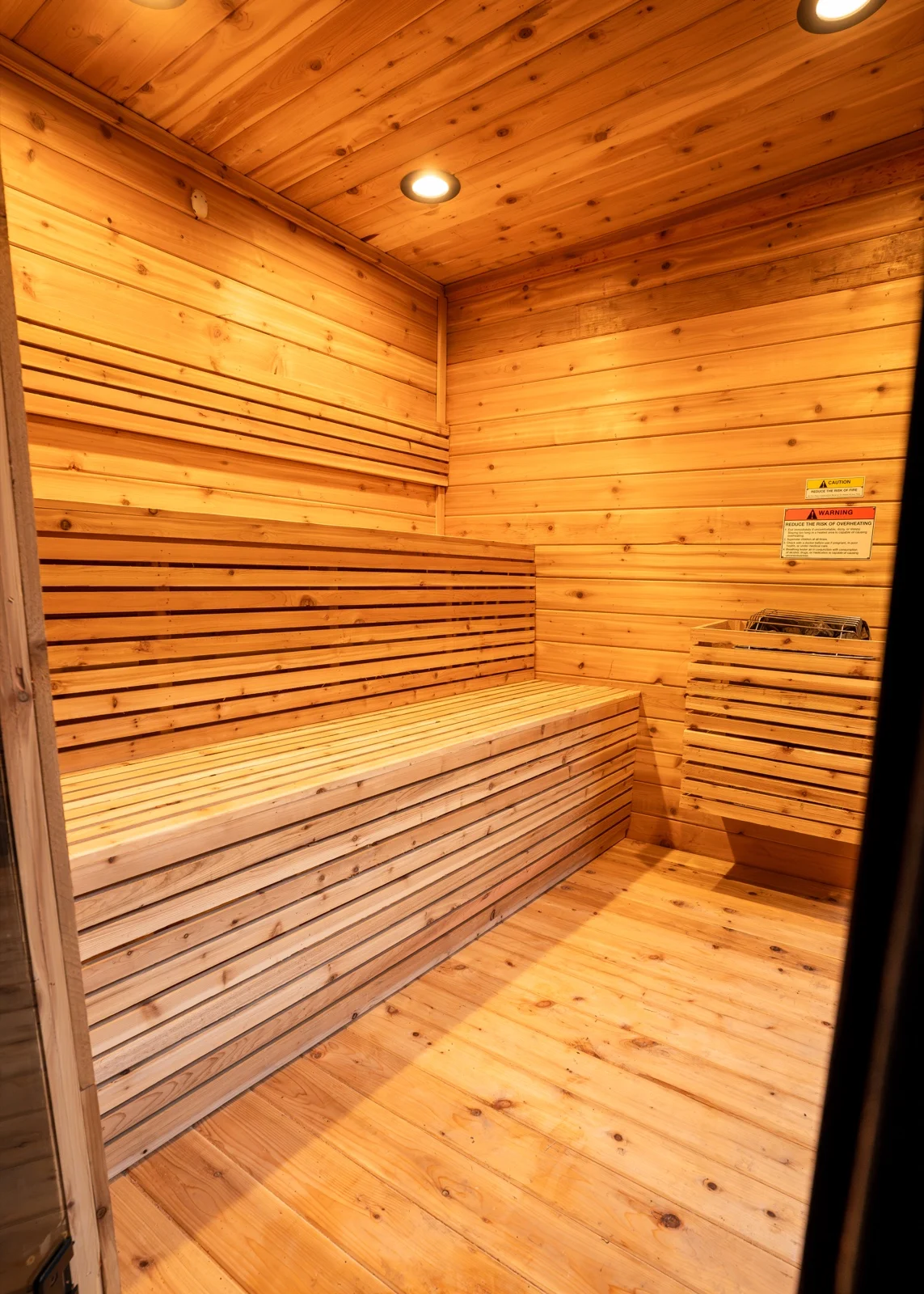 Electric sauna heater with cedar slat guard inside cedar interior