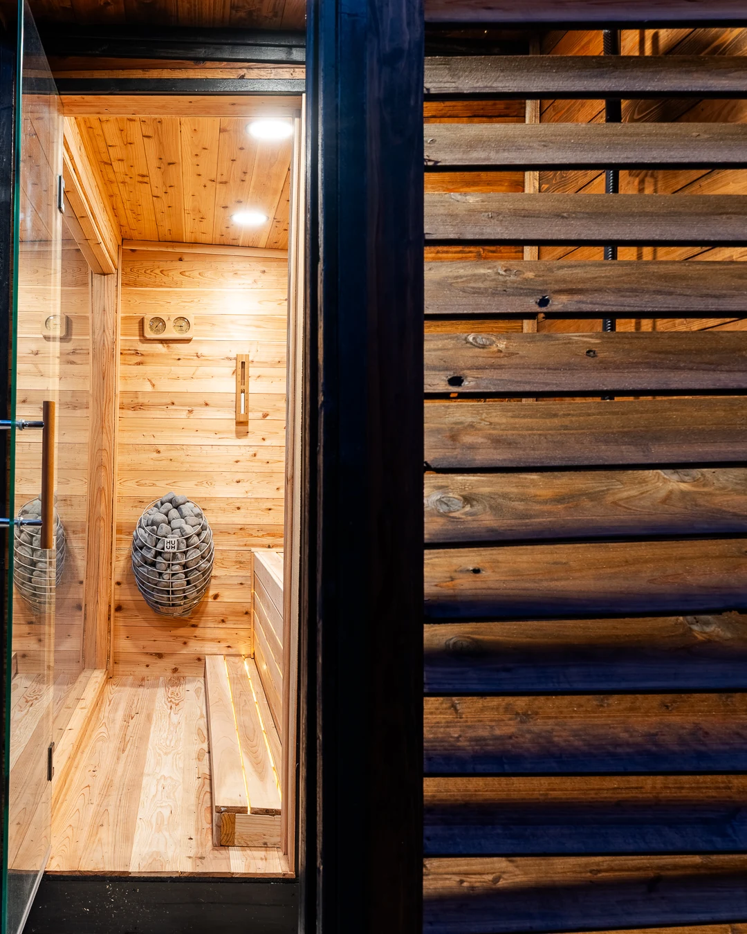 HUUM Drop heater and stepped cedar benches seen through the glass door